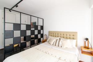 1 dormitorio con 1 cama grande y cabecero blanco y negro en Franca Estadías Temporarias en Rosario