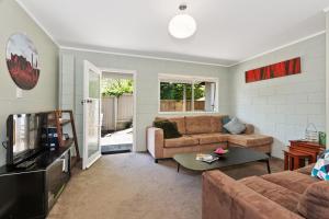 a living room with a couch and a tv at Camellia with WiFi - Paihia Unit in Paihia