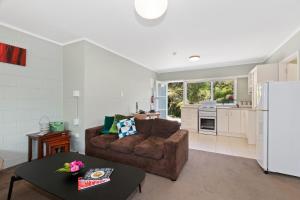 a living room with a couch and a kitchen at Camellia with WiFi - Paihia Unit in Paihia