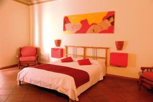 ein Schlafzimmer mit einem Bett und zwei roten Stühlen in der Unterkunft LT Appartamento Teatro Massimo in Palermo