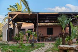 uma casa com uma pérgola e um pátio em Tenuta Luogo Marchese em Pollina