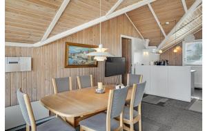 een eetkamer met een houten tafel en stoelen bij Awesome Home In Kge With House Sea View in Valløby