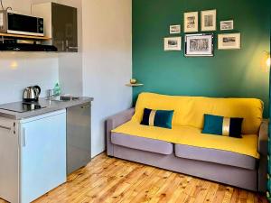 ein Wohnzimmer mit einer gelben Couch in einer Küche in der Unterkunft Le Perrot - Chavant / Centre-ville in Grenoble