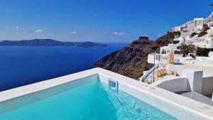 a swimming pool with a view of the ocean at Karpimo Scenery in Firostefani