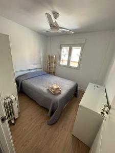 sypialnia z łóżkiem i wentylatorem sufitowym w obiekcie Casa Quintero Valencia Playa Cabañal w Walencji