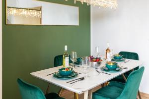 a dining room with a white table and green chairs at L45 Premium Apartment Royale - bis zu 6 Personen in Leipzig