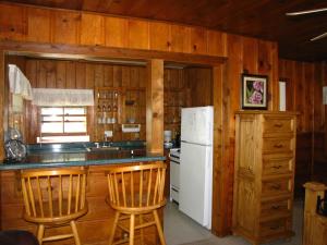 a kitchen with a white refrigerator and wooden walls at Lake Place Resort in Glenhaven