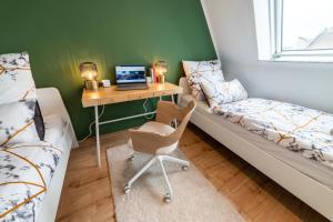 a room with a desk with a laptop and a bed at L45 Premium Apartment Royale - bis zu 6 Personen in Leipzig