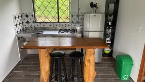 a kitchen with a wooden table and a refrigerator at CABAÑA LA MONTAÑA in San Antonio del Tequendama