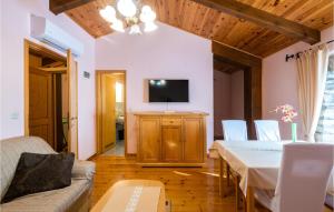 een woonkamer met een tafel en een televisie bij Amazing Apartment In Martinski With Sauna in Martinski