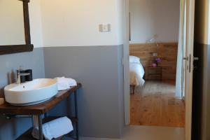 a bathroom with a sink and a room with a bed at Casale Bella.Vista in Pianello Del Lario