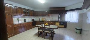 - une cuisine avec des placards en bois, une table et des chaises dans l'établissement Varandas do Dão & Estrela, 