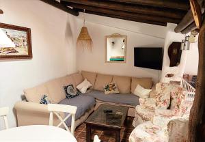een woonkamer met een bank en een tv bij La Apañaora in Galaroza