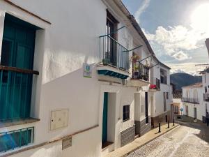 un callejón con edificios blancos y balcón en La Apañaora, en Galaroza