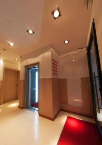 una habitación vacía con alfombra roja y puerta en 29 Cav Apartments, en Bollate