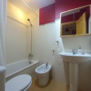 biała łazienka z toaletą i umywalką w obiekcie ADOSADO FAMILIAR w mieście Huelva