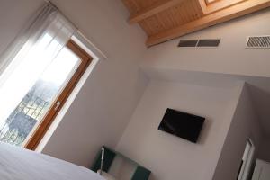 a bedroom with a bed and a tv on the wall at Casale Bella.Vista in Pianello Del Lario