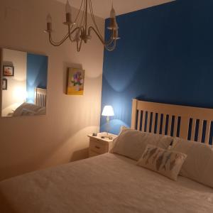 um quarto com uma cama com uma parede azul em ADOSADO FAMILIAR em Huelva