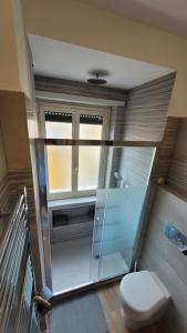 ローマにあるCasa Martaのバスルーム(トイレ、ガラス張りのシャワー付)
