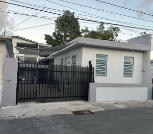 una casa blanca con una puerta y una valla en Perfect suite #1 #3 en San Juan