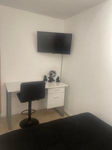 a desk with a chair and a television on a wall at Perfect suite #3 in San Juan