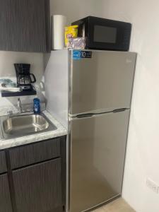 a refrigerator with a microwave on top of it in a kitchen at Perfect suite #3 in San Juan