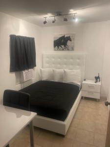 a bedroom with a black and white bed and a window at Perfect suite #3 in San Juan