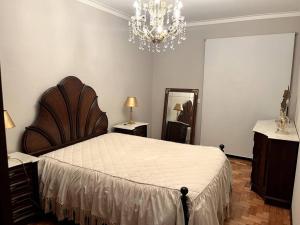 ein Schlafzimmer mit einem großen Bett und einem Kronleuchter in der Unterkunft Olympic Apartment in Braga