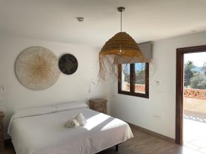 una camera bianca con un letto e una finestra di Cortijo Tayula-Centro de Recuperación y Descanso a Granada