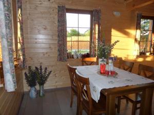 un comedor con una mesa en una cabaña en Domek 12 osobowy na Kaszubach - Agrowczasy U PIANKA 