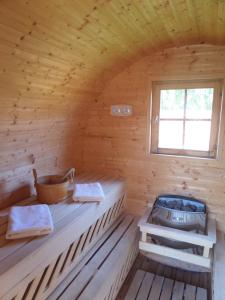 una sauna de madera con bañera y ventana en Domek 12 osobowy na Kaszubach - Agrowczasy U PIANKA 