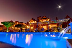 a swimming pool in front of a house at night at Balcón de Nono in Nono