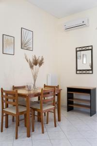 een eetkamer met een tafel en stoelen en een spiegel bij Foto's apartment in Lixouri