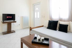 een woonkamer met een bank en een tv bij Foto's apartment in Lixouri