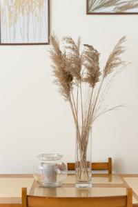 een glazen vaas met gedroogde grassen op een tafel bij Foto's apartment in Lixouri