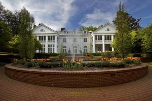 uma grande casa branca com um jardim em frente em The Duke Mansion em Charlotte