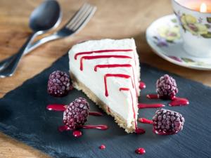 ein Stück Kuchen auf einer blauen Platte mit Himbeeren in der Unterkunft Parkside Hotel in Cleator