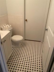 a bathroom with a toilet and a black and white tiled floor at monthly only shared apt in Newport