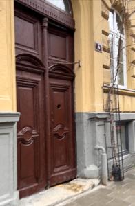 una gran puerta de madera en el lateral de un edificio en 10 Kotliarska Moisha House, en Leópolis
