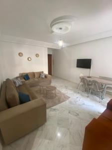 uma sala de estar com um sofá e uma mesa em Magnifique Appartement Vue Mer em Nabeul