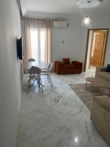 a living room with a table and a couch at Magnifique Appartement Vue Mer in Nabeul