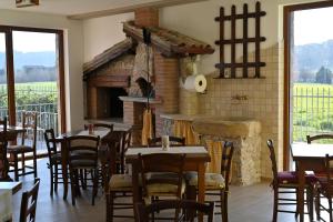 una sala da pranzo con tavoli e camino in mattoni di Agriturismo A Casa Mia Gubbio a Gubbio
