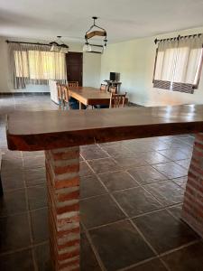 een grote houten tafel in een kamer met een eetkamer bij Punta Sur - Dique Cabra Corral in Cabra Corral