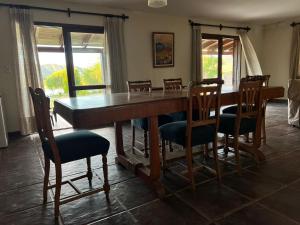 een eetkamer met een grote houten tafel en stoelen bij Punta Sur - Dique Cabra Corral in Cabra Corral