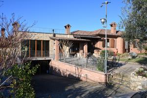 ein altes Backsteinhaus mit einer Veranda und einem Balkon in der Unterkunft Agriturismo A Casa Mia Gubbio in Gubbio