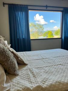 - une chambre avec un lit et une grande fenêtre dans l'établissement Punta Sur - Dique Cabra Corral, à Cabra Corral