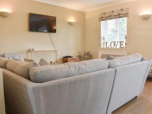 a living room with a large gray couch at The Lodge in Cosham