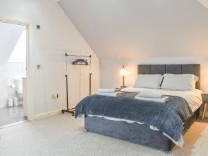 a white bedroom with a large bed with pillows at The Lodge in Cosham