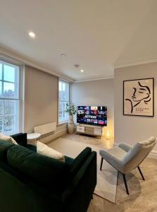 a living room with a green couch and a tv at The Apartments Lytham Square in Lytham St Annes