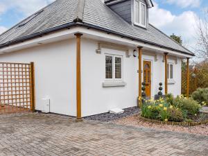 a white house with a gate and flowers at The Lodge in Cosham